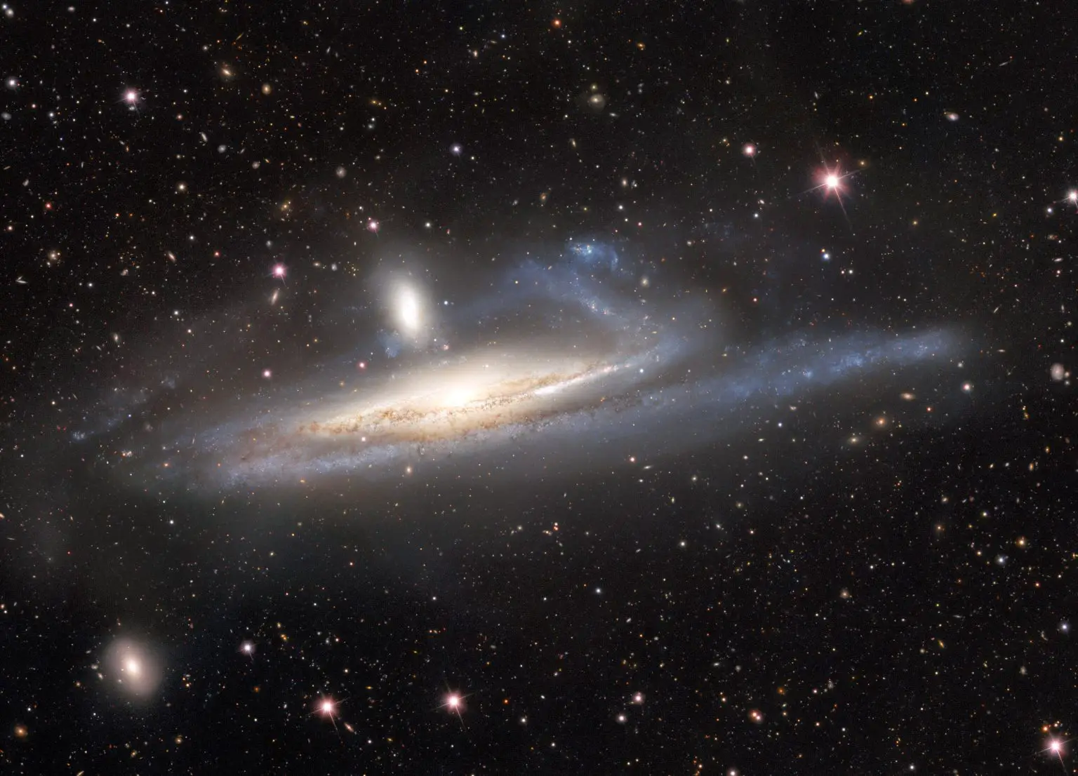 Dark-Energy-Camera-Captures-Galaxies-in-Lopsided-Tug-of-War-1536x1106.webp