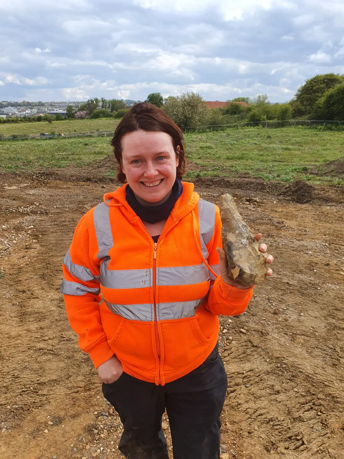 Letty-Ingrey-Holds-Up-One-of-the-Handaxes-on-Site-1152x1536.webp