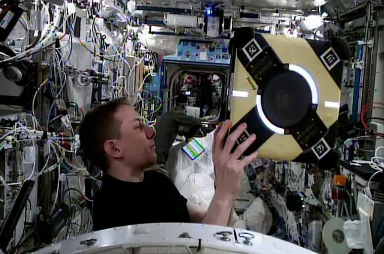 NASA-Astronaut-Woody-Hoburg-Examines-Astrobee-Free-Flying-Robot.webp