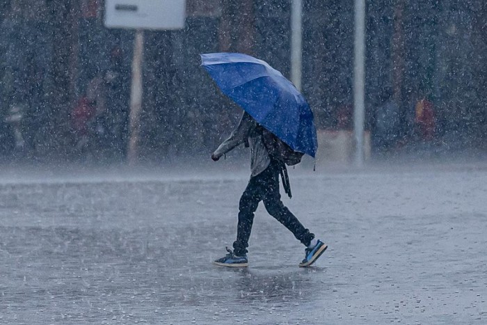 800px-A_man_walks_through_heavy_rain_under_an_umbrella_in_Kigali,_Rwanda._Emmanuel_Kwizera.jpg