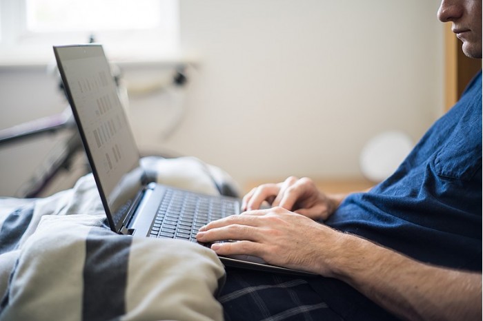 Working_from_Bed_-_A_Man_Works_from_Home_with_a_Laptop_in_Bed.jpg