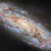 哈勃捕捉到倾斜的螺旋星系 其中充满了早期恒星和发光气体